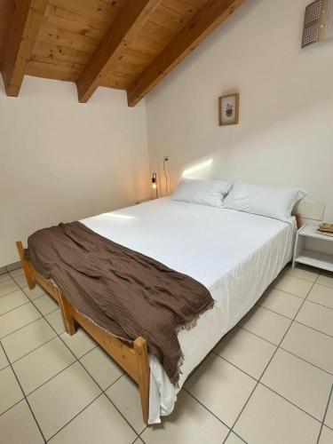 a bedroom with a large white bed in a room at Ostello Casa Rossa in Laveno-Mombello
