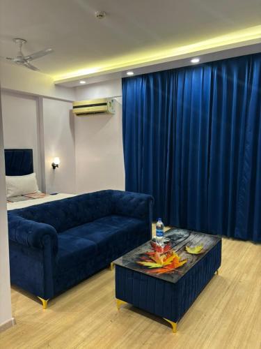 a living room with a blue couch and a table at The Royal Suites Gomti Nagar Lucknow in Lucknow