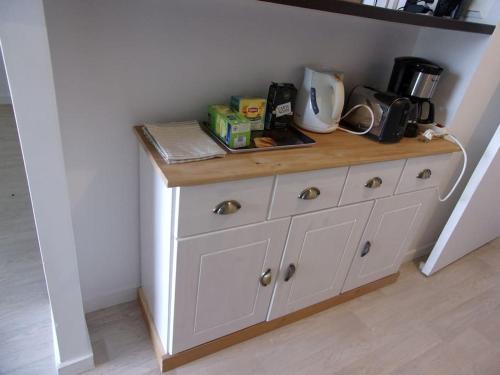 une commode blanche dans une cuisine avec un comptoir dans l'établissement L'escale marine, à Pléneuf-Val-André