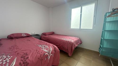 a bedroom with two beds and a window at Mirador Playa in Conil de la Frontera