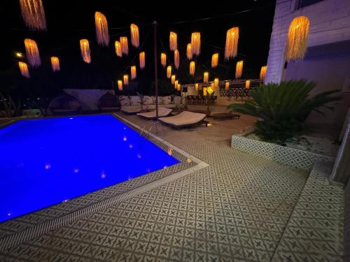 een zwembad in een tuin 's nachts met verlichting bij GÜLER BUTİK HOTEL in Antalya