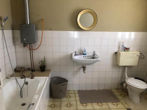 Un baño con bañera, inodoro y lavabo. en Groendeur Guesthouse, en Kotzesrus