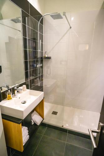 a bathroom with a sink and a shower at Best Western Bridge Hotel Lyon East in Jons