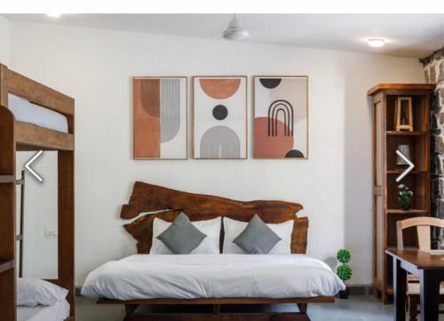 a bedroom with a bed and some pictures on the wall at Jungle stay by Bilwa Estate in SanivÄrsante