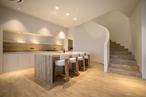 a kitchen with a bar with stools and a staircase at Luxury 4BD Villa with Oceanview in Uluwatu in Uluwatu