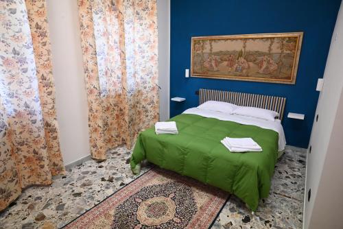a bedroom with a green bed with blue walls and curtains at Villa San Giuseppe Brindisi in Brindisi