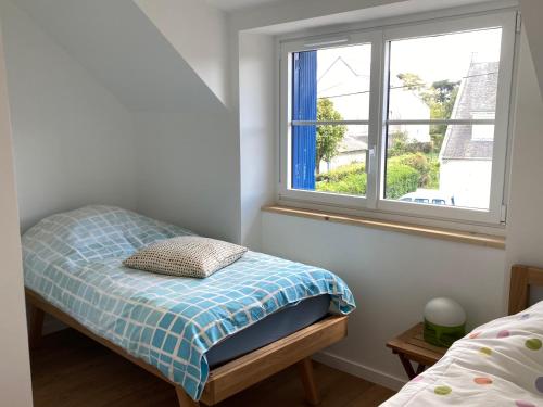 ein kleines Schlafzimmer mit einem Bett und einem Fenster in der Unterkunft Jolie petite maison proche mer in Le Pouliguen