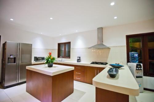 a kitchen with a stainless steel refrigerator and a counter at Villa Origami by Nagisa Bali in Seminyak