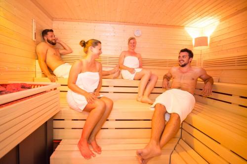 a group of people sitting in a sauna at Hotel Brunnwirt in Weissbriach