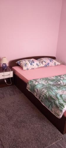 ein Bett mit zwei Kissen darauf in einem Zimmer in der Unterkunft Silva apartman in Sarajevo