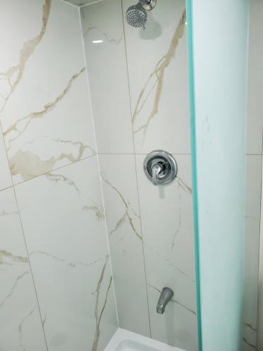 y baño con ducha y azulejos de mármol. en RAESABU GUEST HOUSE en Brampton