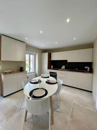 une cuisine avec une table et des chaises dans l'établissement Belle Maison à Tarnac Corrèze, à Tarnac
