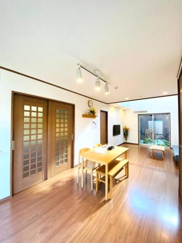 a living room with a wooden table and a dining room at JR京都站3分钟地铁路程 免费专有停车场Wi-Fi 步行可到达伏見稲荷大社 新建筑 日式传统庭院氛围 in Kyoto