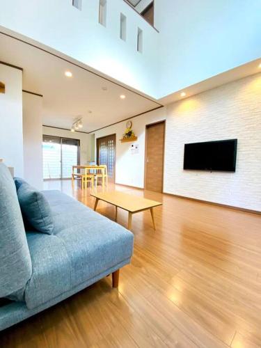 a living room with a couch and a flat screen tv at JR京都站3分钟地铁路程 免费专有停车场Wi-Fi 步行可到达伏見稲荷大社 新建筑 日式传统庭院氛围 in Kyoto