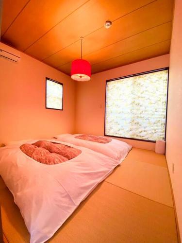 a bedroom with two beds in a room with a window at JR京都站3分钟地铁路程 免费专有停车场Wi-Fi 步行可到达伏見稲荷大社 新建筑 日式传统庭院氛围 in Kyoto