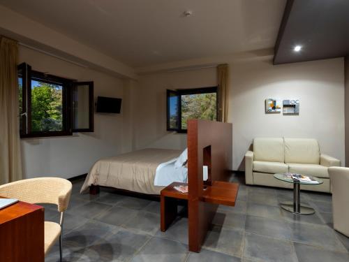 a bedroom with a bed and a couch and a table at Il Castagneto Hotel in Melfi