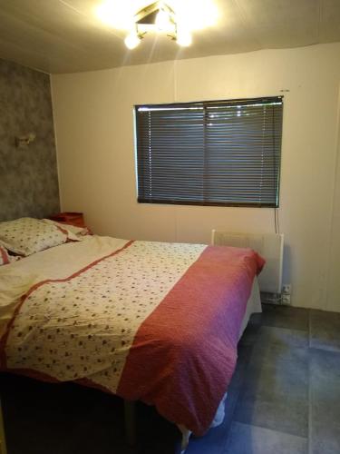 une chambre avec un lit et une fenêtre dans l'établissement mobile home Norman à louer dans un charmant village, à Blangy-le-Château