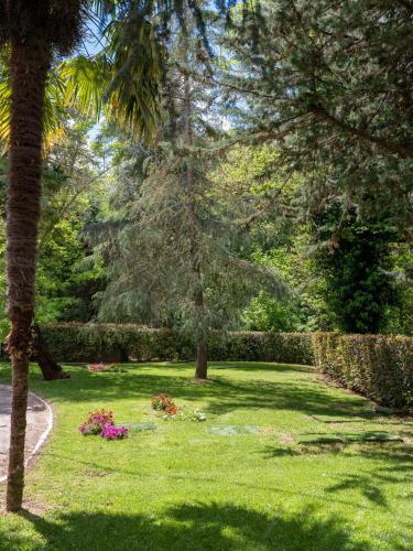 a garden with trees and flowers in the grass at Il Castagneto Hotel in Melfi