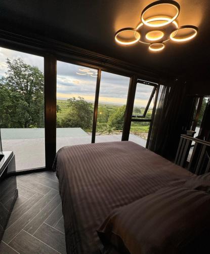 a bedroom with a bed and a large window at Eco House 1 in Prestatyn