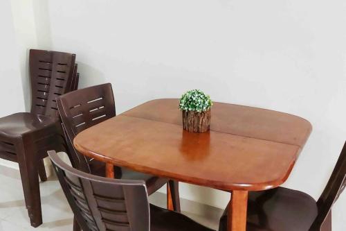 a wooden table and chairs with a plant on it at Serdang Greenseeds Homestay 9-10pax MIECC in Seri Kembangan