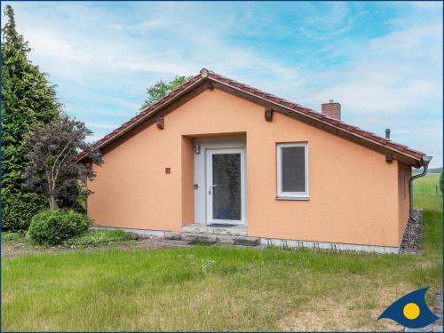 una pequeña casa naranja con una puerta blanca en Ferienhaus Pauline, en Trassenheide