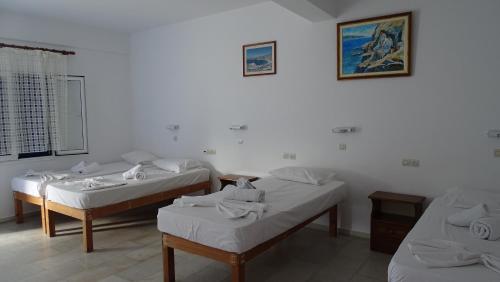 a room with three beds in a room at Hermes-Ios Rooms To Let in Ios Chora