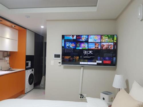 a tv hanging on a wall in a bedroom at Daon 동성로 스타비앤비 레지던스 in Daegu