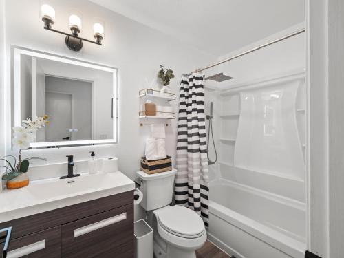 a bathroom with a toilet and a sink and a shower at Super Spacious Family Vacation House! in San Diego