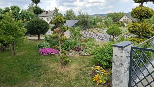 a garden with colorful flowers and a fence at Noclegi w Dolinie Drwęcy in Kurzętnik