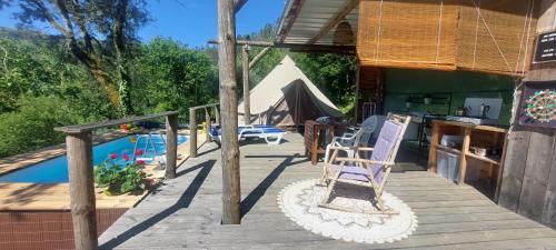 une terrasse avec une chaise et une piscine dans l'établissement Bell-tenten Quinta Pomar Do Pontido, à Cabeceiras de Basto