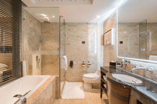 y baño con bañera, aseo y lavamanos. en Lake View Hotel, en Beijing