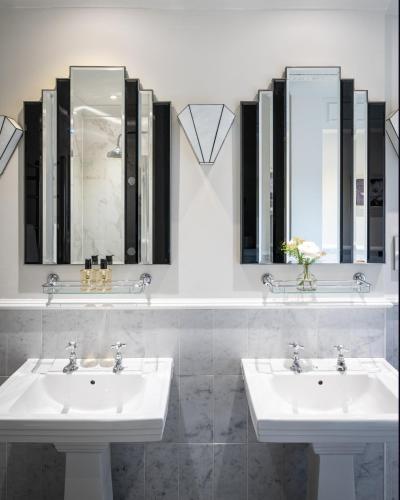 two sinks in a bathroom with two mirrors at Rookery Hall Hotel & Spa in Nantwich