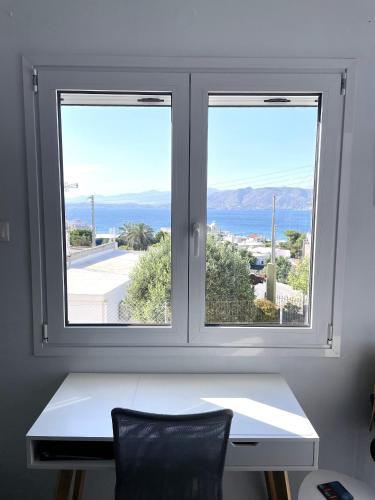 a window with a white desk and a view of the ocean at Socratous House in Salamís