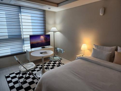 a bedroom with a bed and a desk with a computer at Daon 동성로 스타비앤비 레지던스 in Daegu