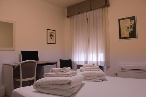 um quarto com duas camas com toalhas brancas em Hotel Roma em Palmanova