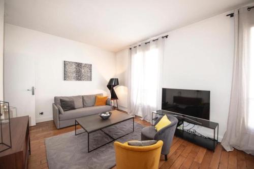 un salon avec un canapé et une table dans l'établissement Appartement élégant Paris centre, à Paris