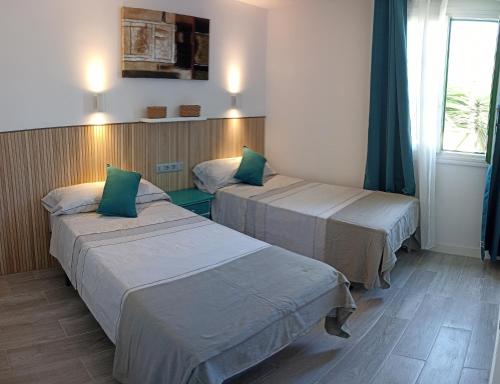 a hotel room with two beds and a window at Casa Gioeli Cocosol in Costa de Antigua