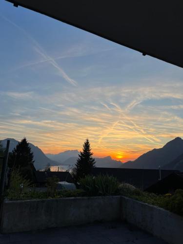 a view of the sunset from the balcony of a house at Appartement Seelewärmerli - Balsam für Ihre Seele in Seelisberg