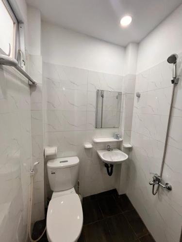 a white bathroom with a toilet and a sink at Lotus Home-Sunrise Home Extra Best Quality in Ho Chi Minh City