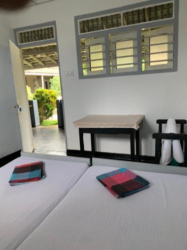 a bed with two plates on it with a table at Flexi Lodge in Negombo