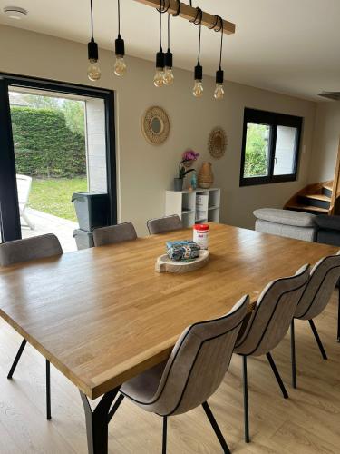 une salle à manger avec une table et des chaises en bois dans l'établissement villa Le Sillage, à Jullouville