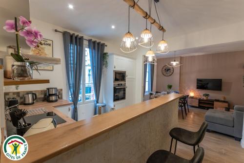 une cuisine et un salon avec un bar dans une pièce dans l'établissement Charmante Maison centre-ville avec terrasse !, à Épernay