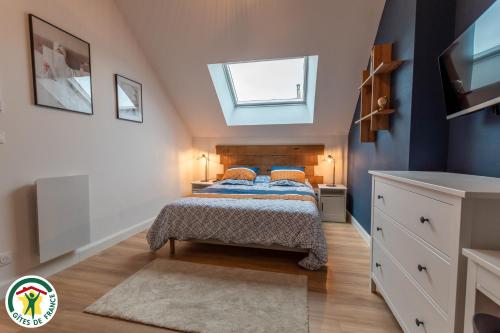 - une chambre avec un lit aux murs bleus et une lucarne dans l'établissement Charmante Maison centre-ville avec terrasse !, à Épernay