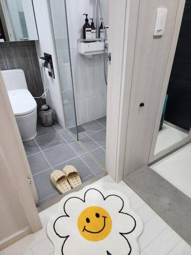a bathroom with a shower with a flower rug on the floor at Daon 동성로 스타비앤비 레지던스 in Daegu