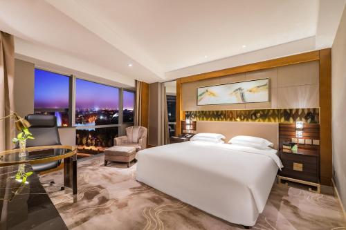 a bedroom with a large white bed and a desk at Lake View Hotel in Beijing