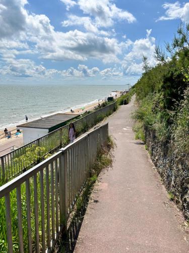 a path next to a beach with the ocean at VerbJam 6 Berth Caravan Holiday St Osyth Clacton-on-sea in Clacton-on-Sea