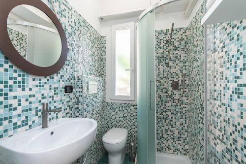 Un baño con lavabo, inodoro y espejo. en Appartamento Pet-Friendly Vista Mare Recco, en Recco