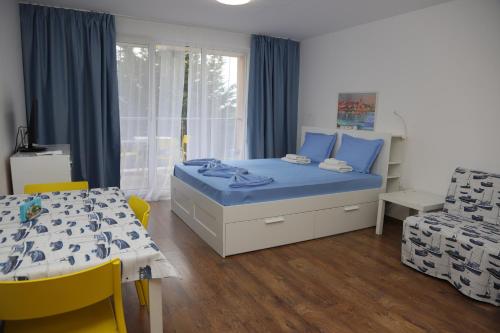 1 dormitorio con 1 cama, mesa y sillas en Lux Sozopoli Hills Apartments A19 и Studio А13, en Sozopol
