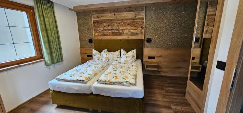 a bedroom with a bed with pillows on it at Hotel-Garni Pramstraller in Mayrhofen