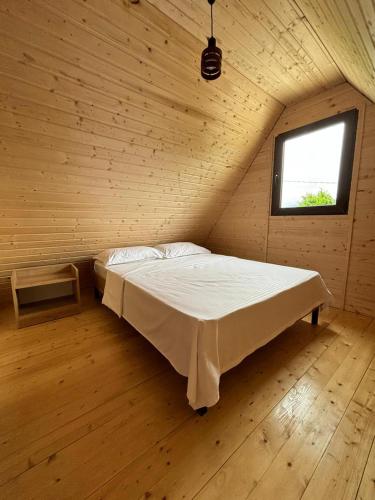a bed in a wooden room with a window at Cozy Cottages Kondidi in Kobuleti